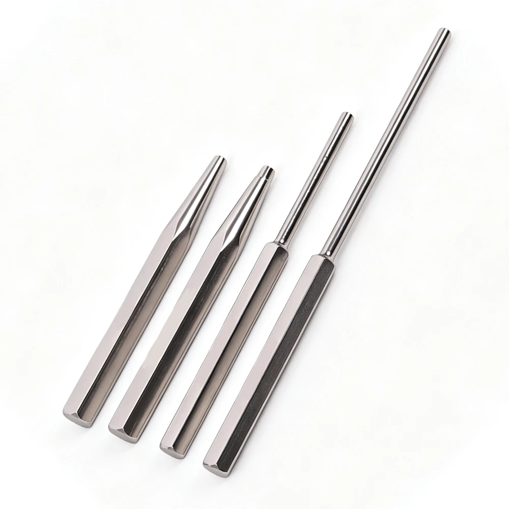 Four polished metal punches arranged on a white background, including two tapered punches and two long pin punches.